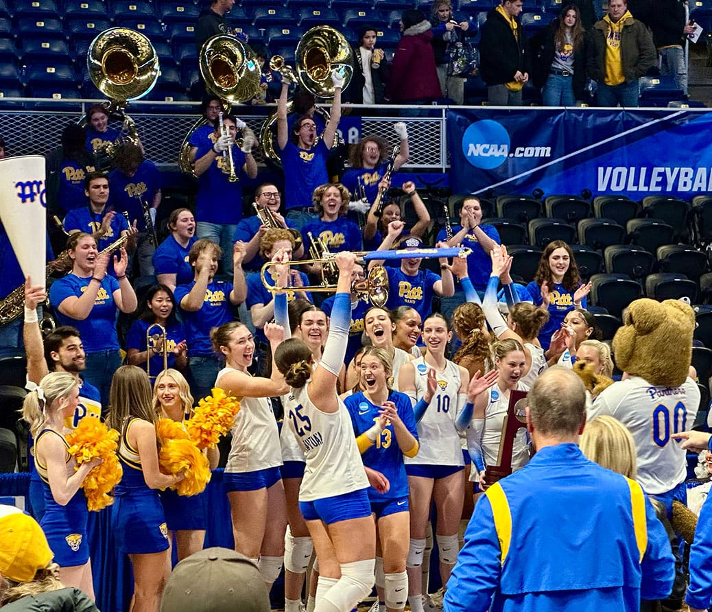 Haiti Tautua'a celebrates with a brass instrument with her team and the Pitt band