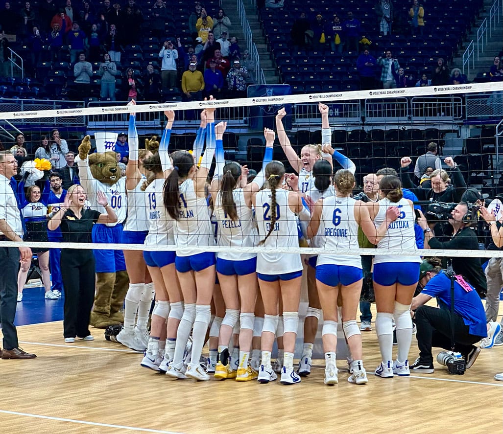 Brooke Mosher and her teammates celebrate with Roc the Panther after placing their name on the final four card.